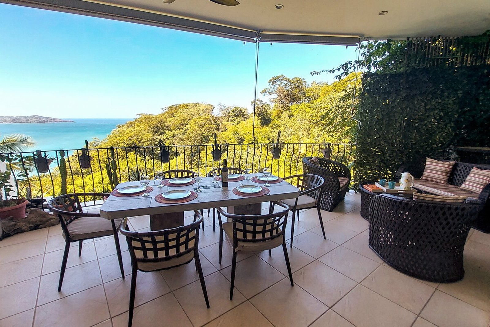 Covered terrace with dining table overlooking the Pacific and Flamingo bay